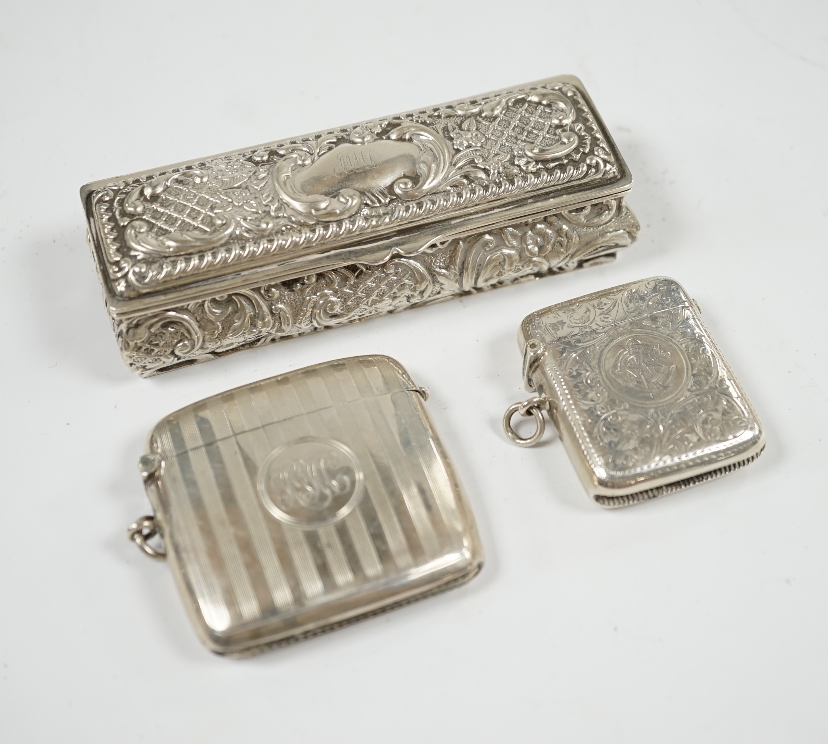 Two early 20th century silver vesta cases and an Edwardian repousse silver trinket box, 11cm. Condition - fair
